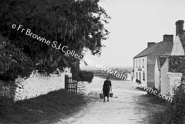 WOMAN CARRYING WATER AT PAROCHIAL HOUSE